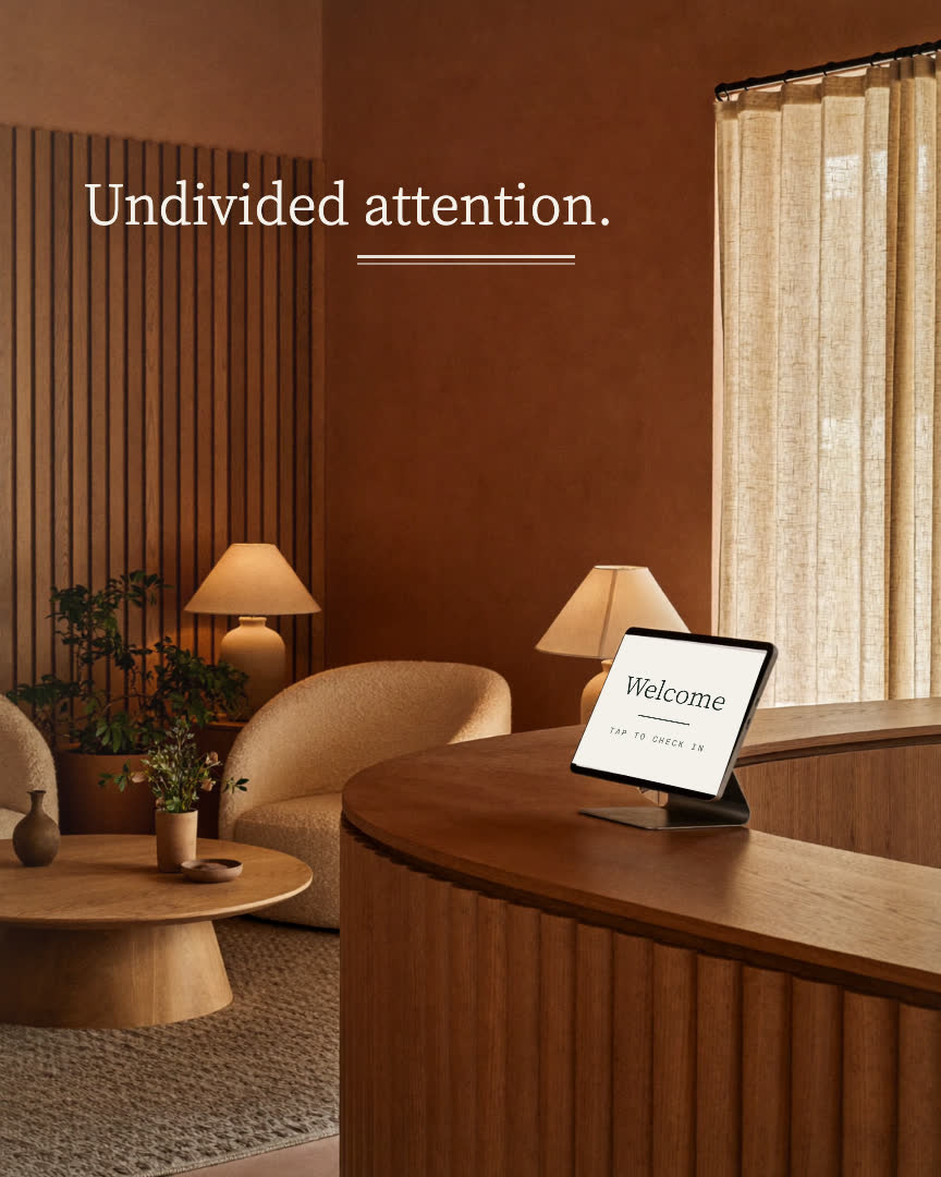 AI Automation brand film still: a consulting room desk with a face-down phone and the line Undivided attention